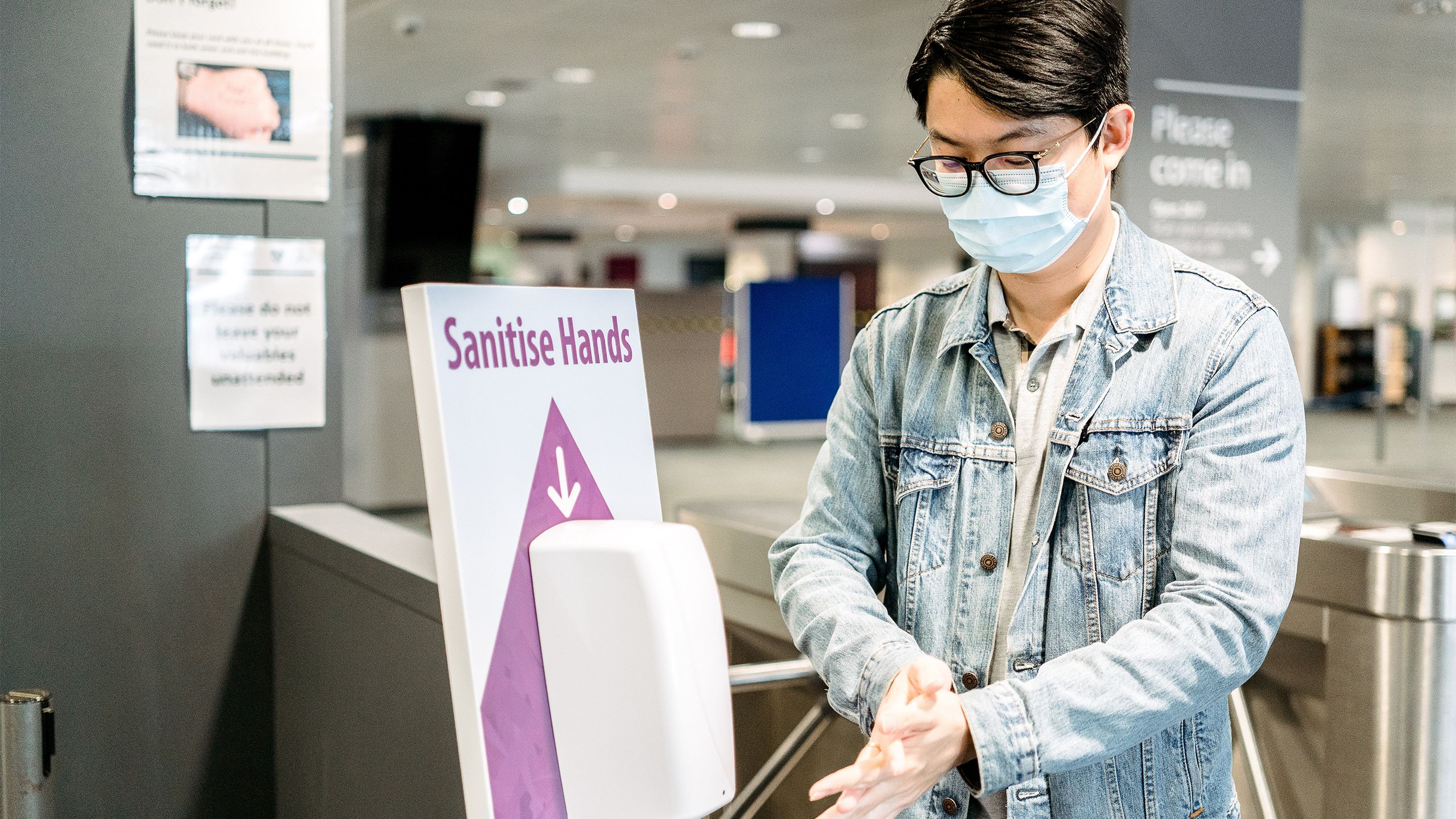 A male student sanitising his hands in the Library
