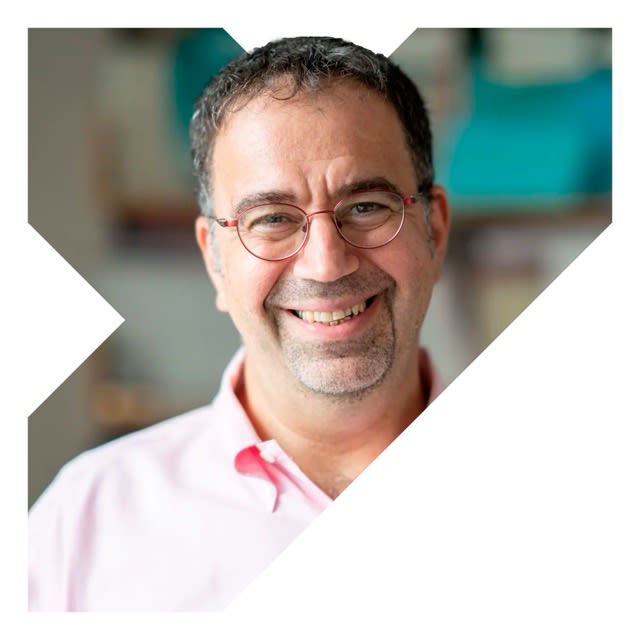 Daron is a man with short dark hair who is smiling and wearing glasses