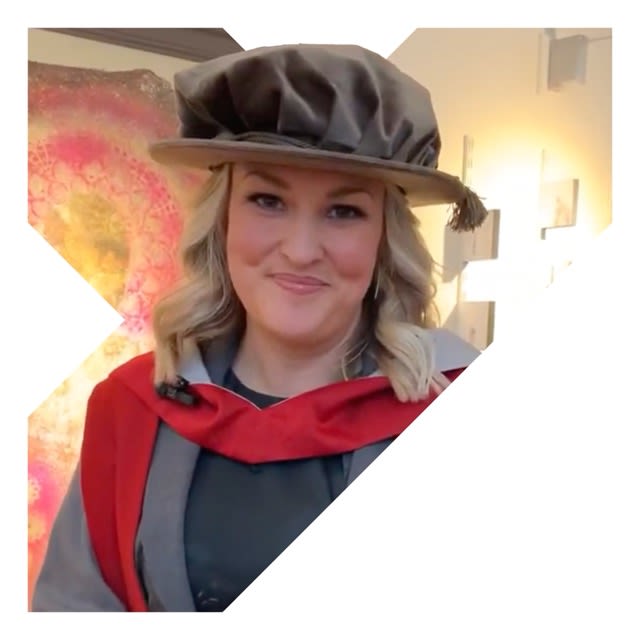 Sara Davies is wearing a graduation outfit and smiling